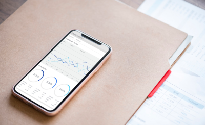 Smartphone con gráficos de gasto, ahorro y presupuesto en euros en España.