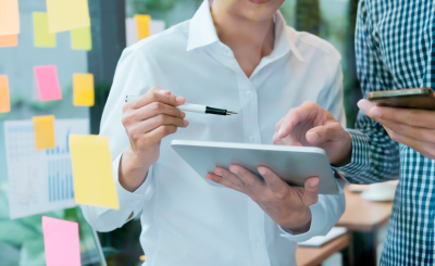 Dos inversores revisando estrategias de diversificación de cartera en una tablet y smartphone, planificando inversiones en España con enfoque a largo plazo