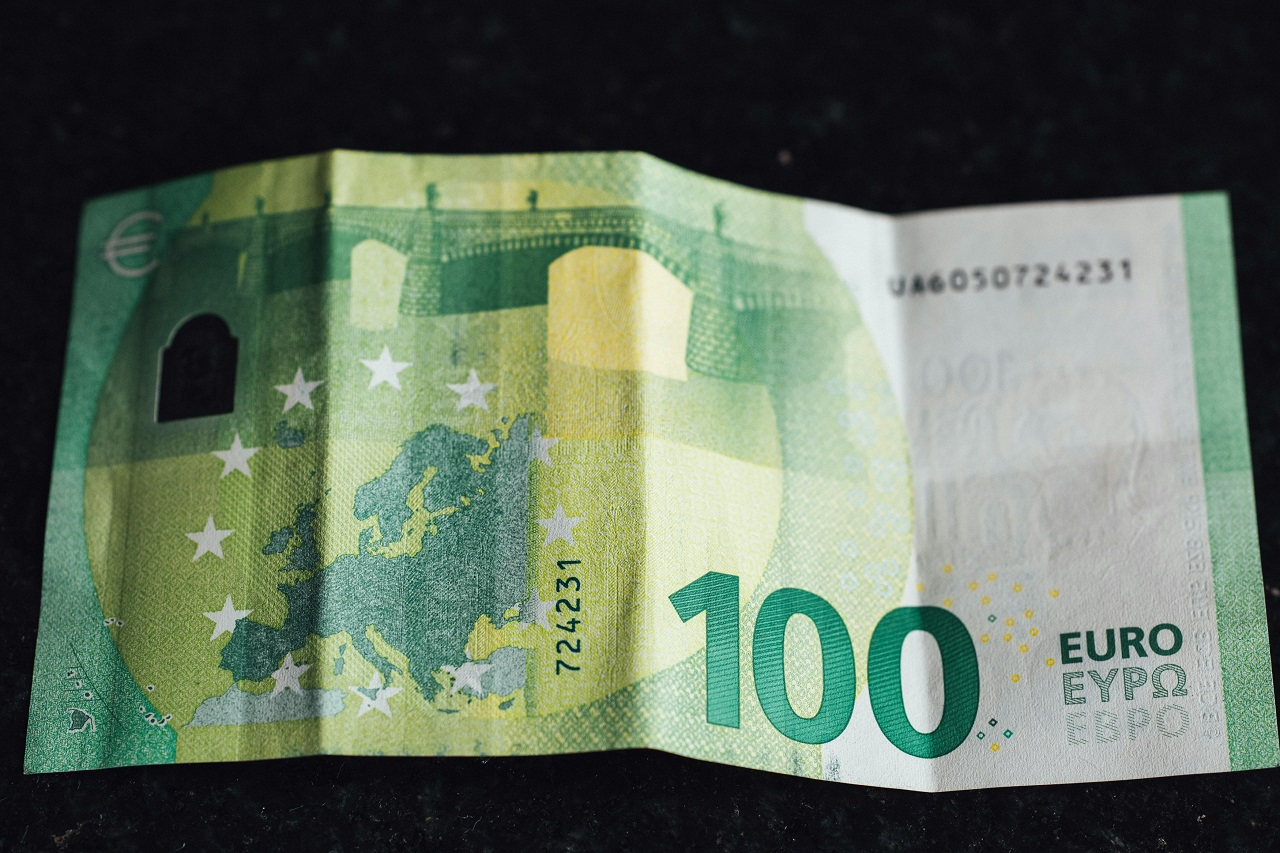 Billete de 100 euros sobre una mesa, representando la estrategia de inversión mensual de 100 € en España.