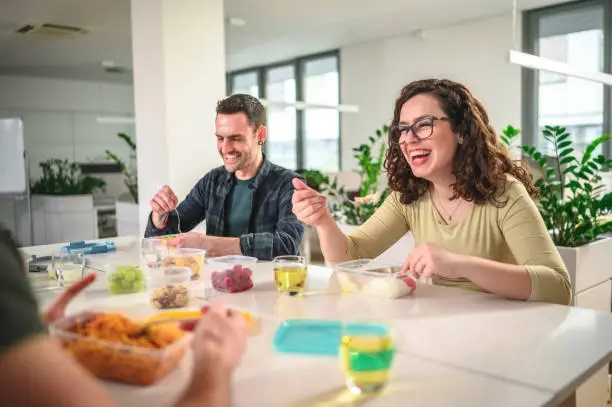Empleado en España comiendo almuerzo barato y saludable de tupper en la oficina