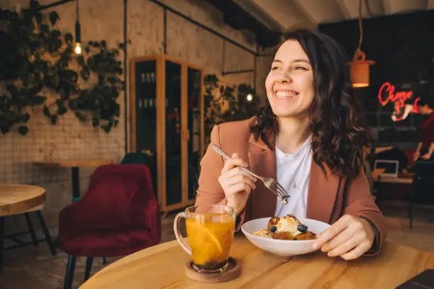 Mujer disfrutando una comida gratis como parte de su experiencia como cliente misterioso.