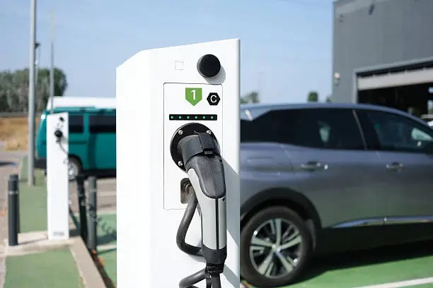 Coche eléctrico recargando energía en punto público rápido en España.