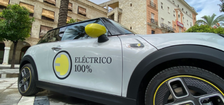 Coche eléctrico 100 % circulando por una ciudad española en 2025, representando la movilidad sostenible y el menor coste por kilómetro frente a gasolina y diésel.