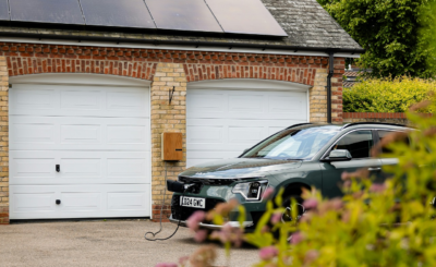 Coche eléctrico cargando en el garaje de una vivienda española en 2025, simbolizando el bajo coste de carga doméstica frente a puntos públicos.
