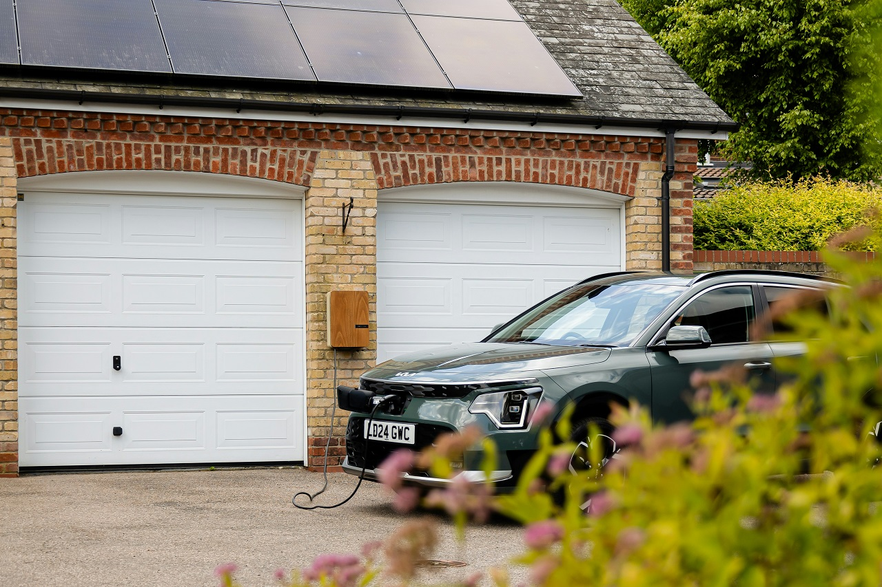 Coche eléctrico cargando en el garaje de una vivienda española en 2025, simbolizando el bajo coste de carga doméstica frente a puntos públicos.