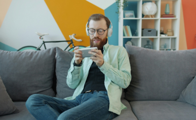 Persona jugando con el móvil en casa mientras gana dinero real a través de apps en España 2025.